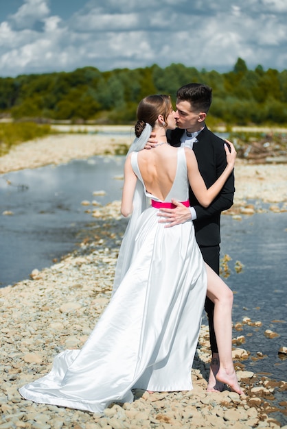 young bride and groom near the river