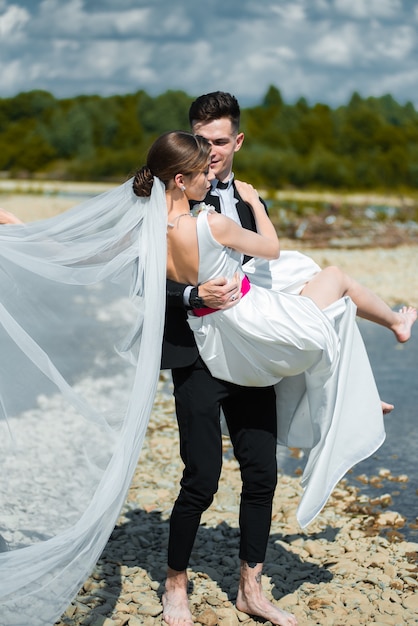 young bride and groom near the river