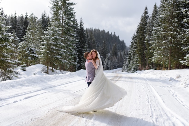 Young bride and groom on the snowy forest