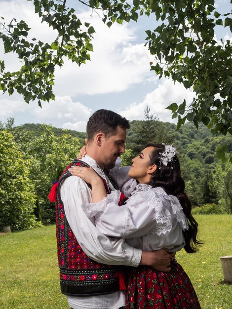 Young bride and groom wearing romanian traditional in Maramures Romania