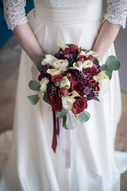 Young bride holds spring wedding bouquet