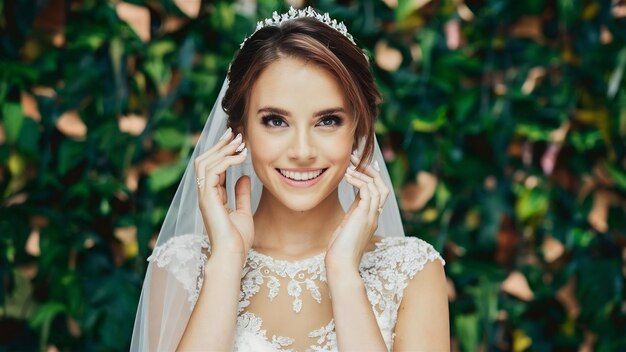 The young bride is looking happily and mysteriously in the camera