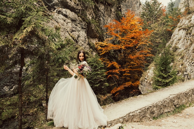 Young bride posing on a background of mountains.