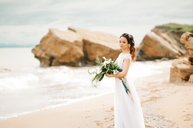 Young bride on a sandy beach at a wedding walk