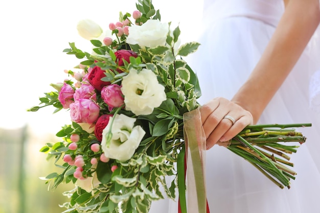 Foto giovane sposa con il mazzo del primo piano dei fiori