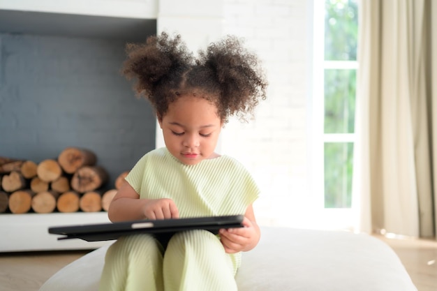 A young bright cute little girl with her trusty tablet that makes her happy and joyful