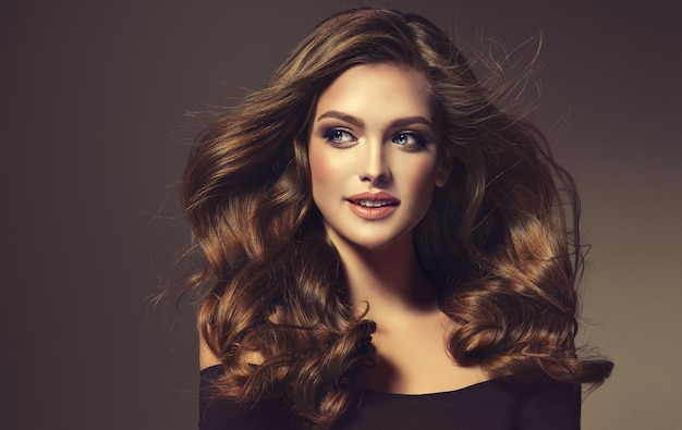 Young brown haired beautiful model with long wavy well groomed hair Hair care Makeup Flying hair