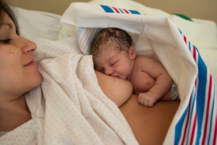 Photo 幼い茶色の女性が新生児の娘に母乳を授けている 母親の概念