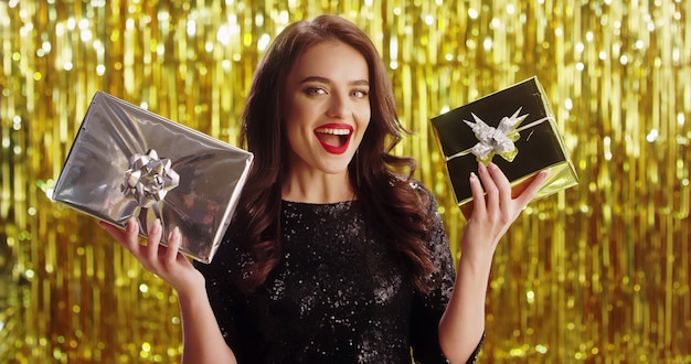 Young brunette blonde woman in fancy dress with presents in hands