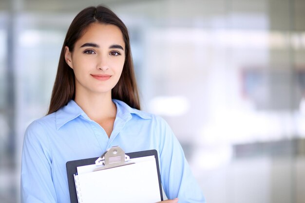 Young brunette businesswoman or student girl looking at camera