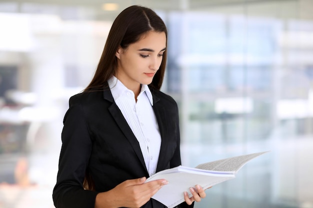 Young brunette businesswoman or student girl looking at camera