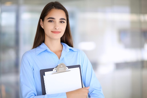 Young brunette businesswoman or student girl looking at camera