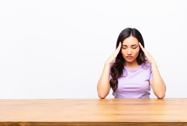 young brunette at a desk looking concentrated and inspired