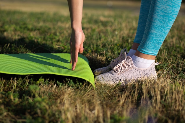 Photo young brunette girl doing yoga and stretching with yoga mat. space for text