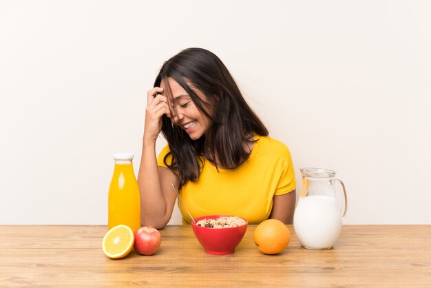 Young brunette girl having breakfast milk laughing