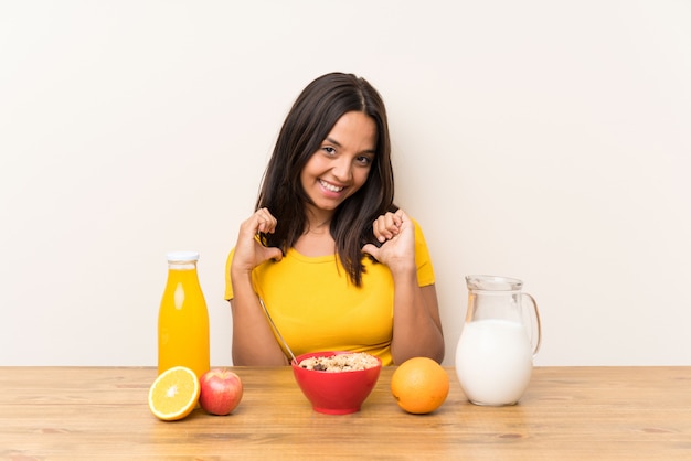 Young brunette girl having breakfast milk proud and self satisfied