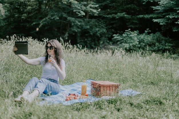 森のピクニックで若いブルネットの少女