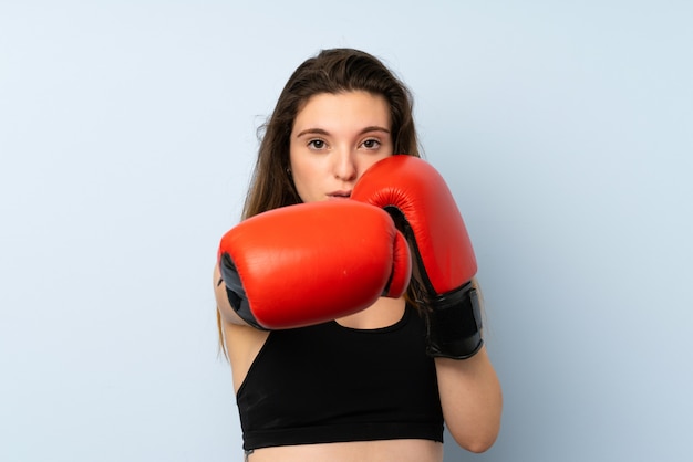 Young brunette girl with boxing gloves over isolated wall