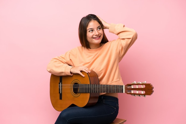 Young brunette girl with guitar background has realized something and intending the solution