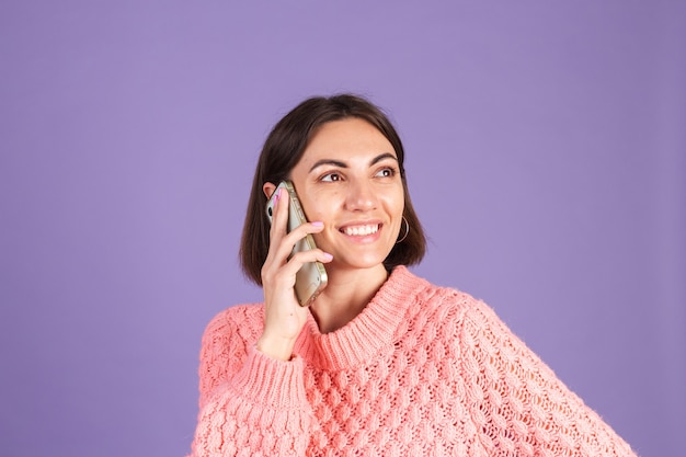 Young brunette isolated on purple wall