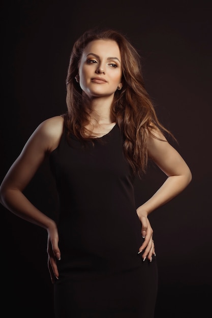 Young brunette model with magnificent hair in the wind. Studio portrait