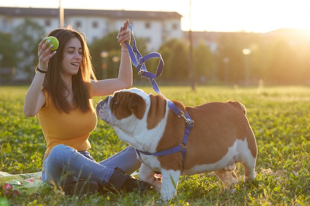 Young brunette play with her british bulldog