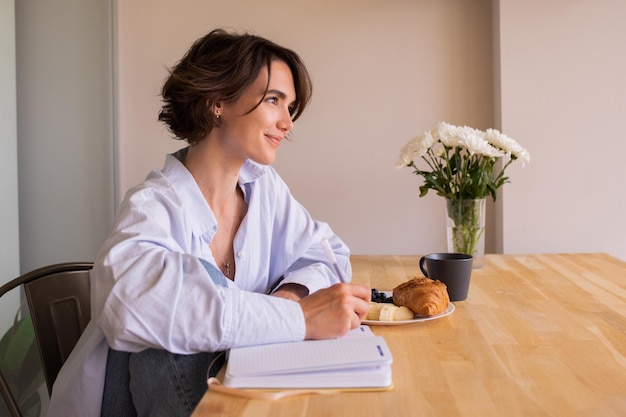 Young brunette smiling woman at home look away