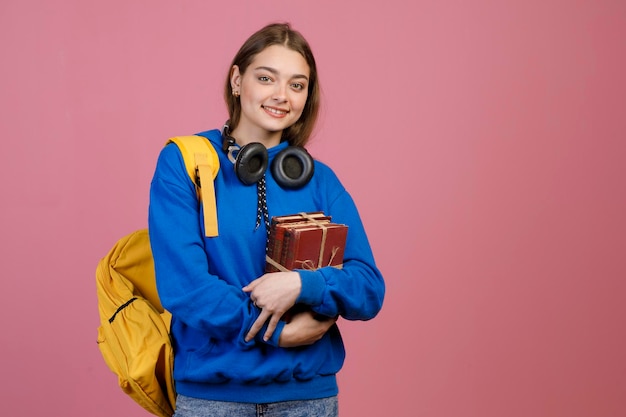 Young brunette student standing with crossed hands