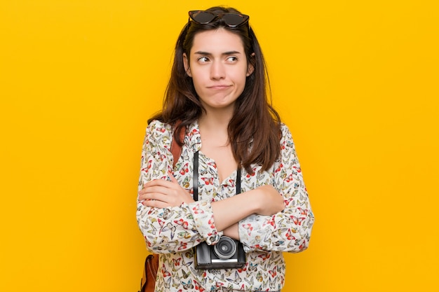 Young brunette traveler woman confused, feels doubtful and unsure.