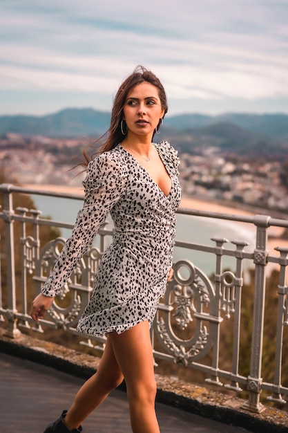 a young brunette walking in the viewpoint of the city of San Sebastian