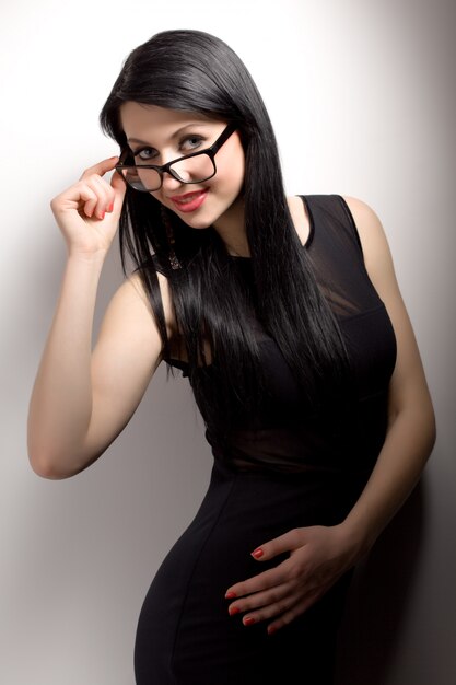 Young brunette woman in black clothing and glasses