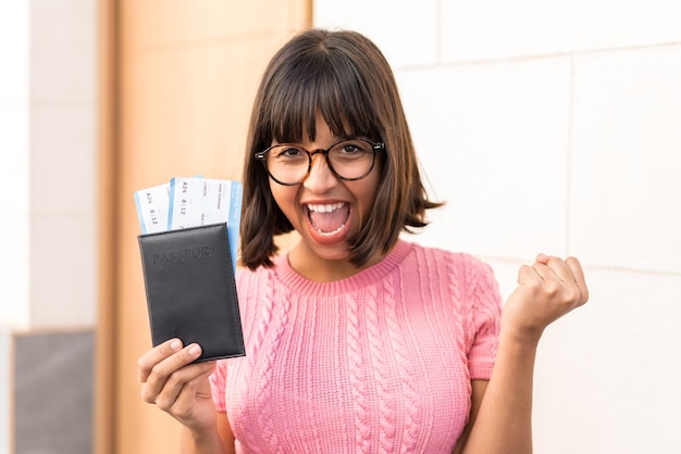 Young brunette woman in the city happy in vacation with passport and plane tickets