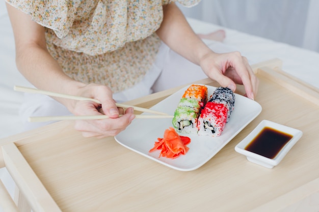 Young brunette woman eating sushi