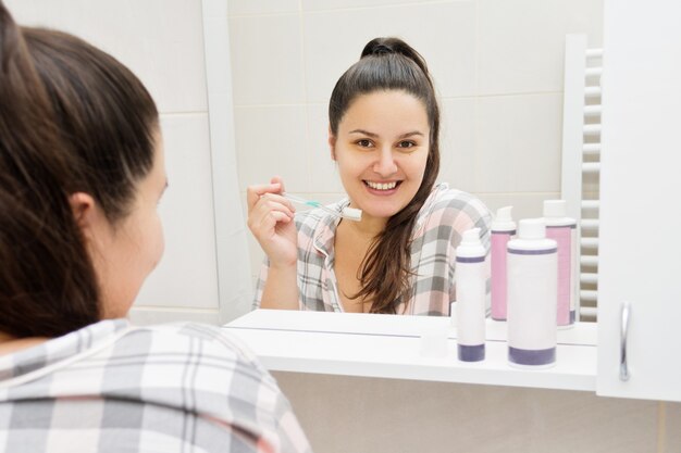 Young brunette woman in front of the mirror