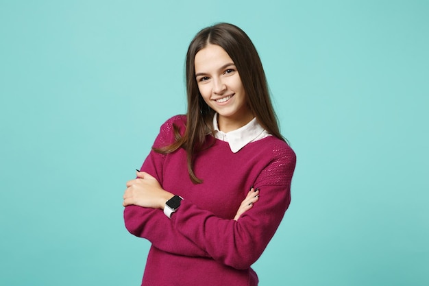 Young brunette woman girl in casual clothes posing isolated on blue green turquoise wall background studio portrait. People sincere emotions lifestyle concept. Mock up copy space. Looking camera smile