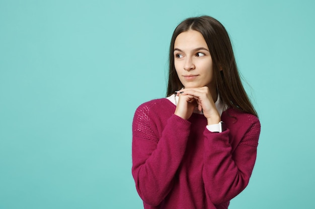 Young brunette woman girl in casual clothes posing isolated on blue green turquoise wall background studio portrait. People sincere emotions lifestyle concept. Mock up copy space. Looking camera smile