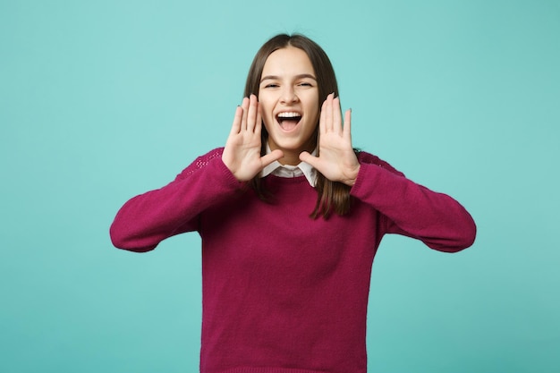 Young brunette woman girl in casual clothes posing isolated on blue green turquoise wall background studio portrait. People sincere emotions lifestyle concept. Mock up copy space. scream with hand nea