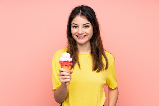 Young brunette woman holding a cornet ice cream   pink  smiling a lot