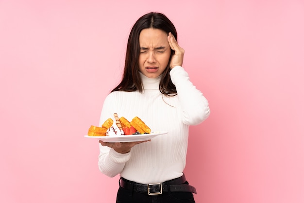 孤立したワッフルを保持している若いブルネットの女性