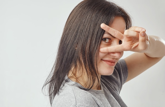 Young brunette woman looking through her fingers