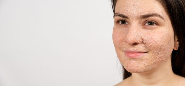 Photo a young brunette woman makes cleansing facial treatments