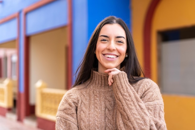 Giovane donna castana all'aperto con espressione felice