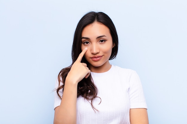 young brunette woman pointing to her eye