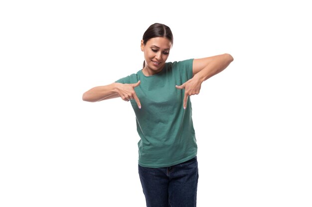 Photo young brunette woman pointing her hand down at the advertising space