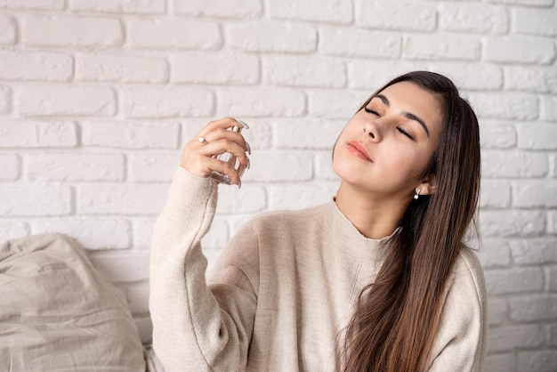 Young brunette woman sitting in the bed making up