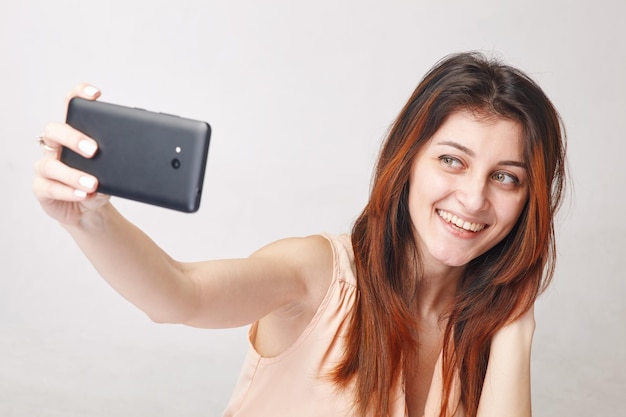 Giovane donna castana che prende selfie