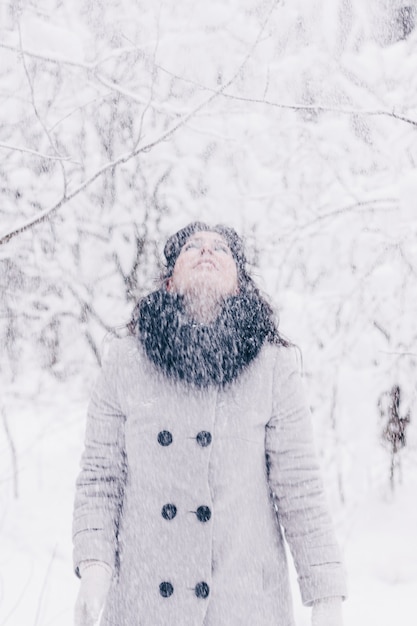 Foto la giovane donna castana vomita la neve nella foresta invernale