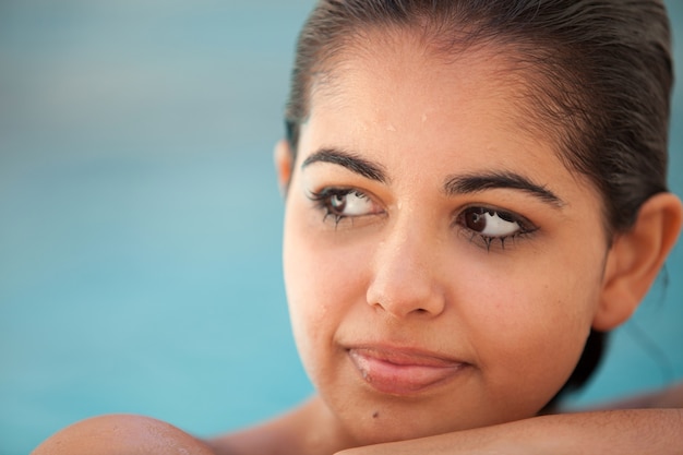 Young brunette woman wet in the pool