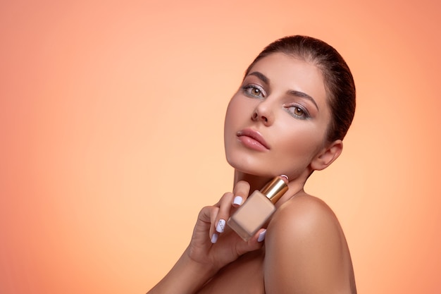 Photo young brunette woman with foundation