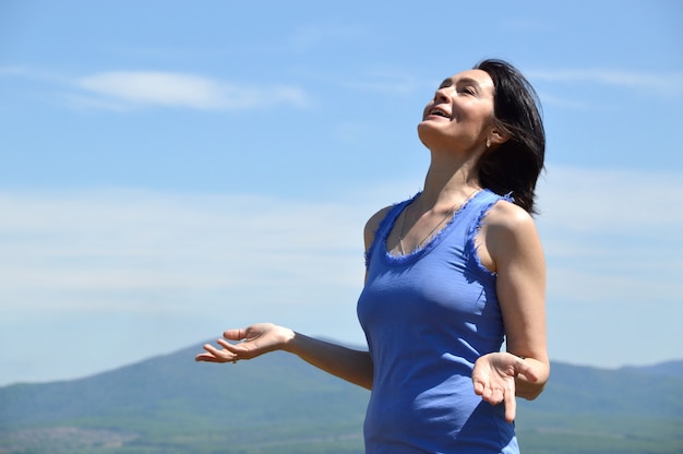 Young brunette woman with her head raised to the sky enjoying freedom